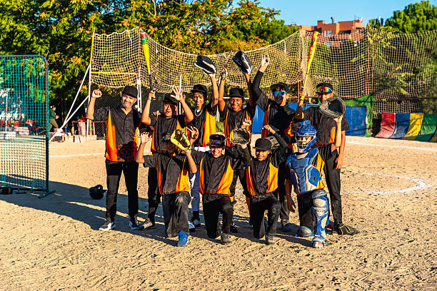 Youth baseball team and coach celebrating a big win on the practice field, raising bats and gloves in joyful cheer, smiling teammates sharing victory and pride