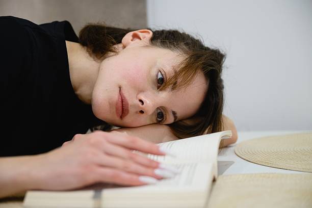 istock Woman reading book at table in modern kitchen 2255647735