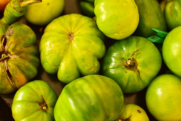 Fresh green tomatoes stacked at the grocery store