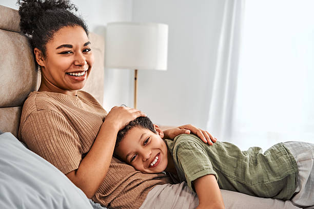 istock Happy mother relaxing on bed with her smiling son. 2255673249