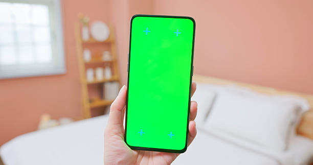 Closeup view of asian people hold a straightly mobile phone show green screen in the room