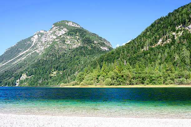he beautiful blue green turquoise Predil lake in Italy, with mountains in background, close to the Slovenian border.