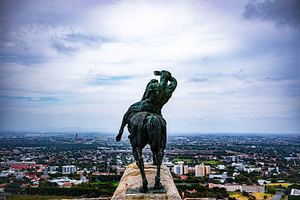The iconic Greek-inspired Rhodes Memorial in Cape Town, perched on the slopes of Table Mountain with panoramic views of the city and ocean, captured in warm sunset light to highlight its grand columns and historical significance as a tribute to Cecil Rhodes.