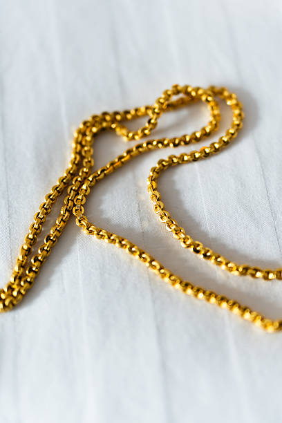 Gold clasps of a golden chains hanging in the air. Soft focus. Copy space.