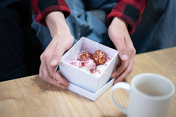 Close-up of hands opening a Valentine's Day gift box