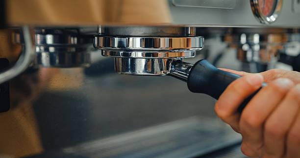 Close-up of an espresso machine brewing fresh coffee into a white cup, highlighting the process and barista equipment. Cafe lifestyle.