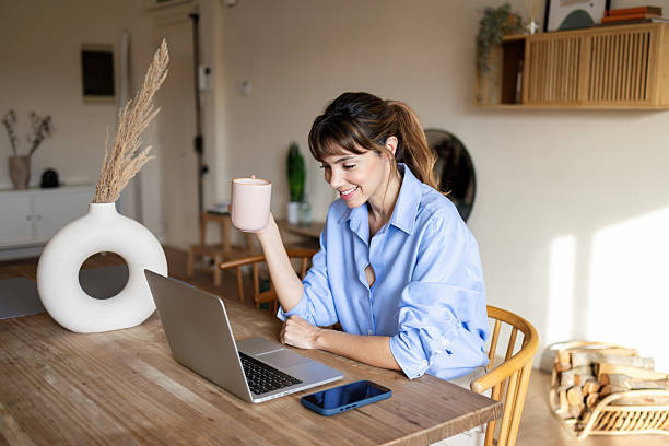 istock Woman working remotely at laptop while drinking coffee 2255695017