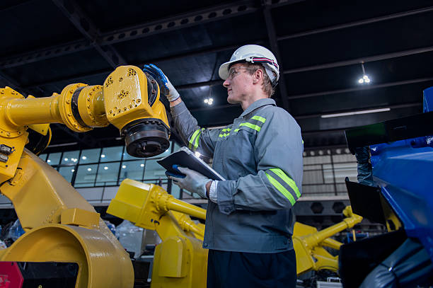 istock Engineer standing by robotic arm and operating machine in industry factory, technician worker check for repair maintenance electronic operation. 2255697469