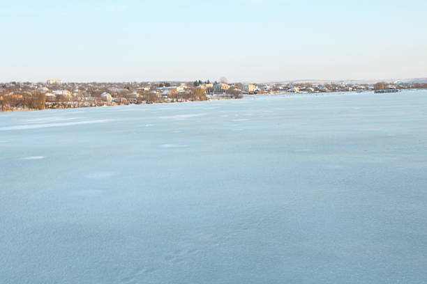 A snowy landscape with buildings. Sky. Outdoor. Nature. Shore. Distance