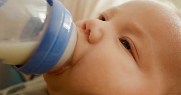 istock Mom feeds formula her newborn son from a bottle. 2255706557
