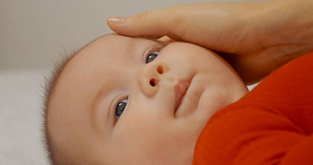 istock Charming baby playing legs and arms while lying on the bed. 2255708904