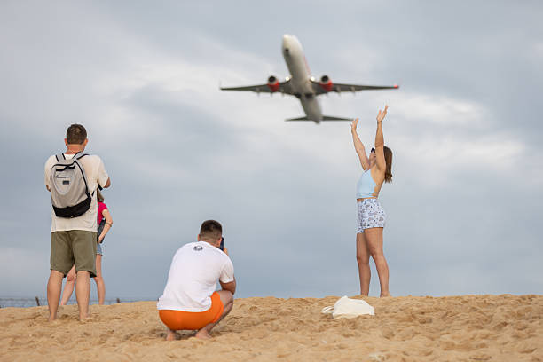 14 November 2025, Phuket Island - Thailand.Group of tourist is taking photo of commercial airplane on the beach.