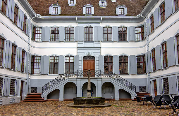 Historic Basel courtyard building showing balanced architecture, central fountain, and calm urban atmosphere.