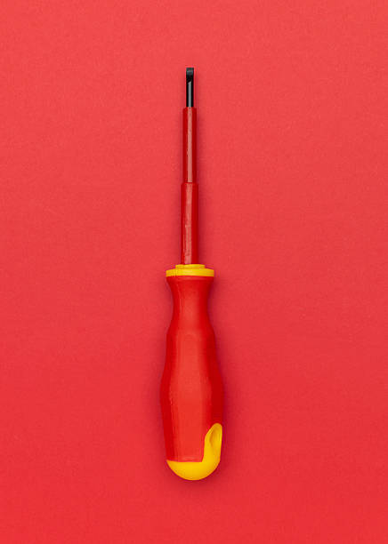 Red Flathead Screwdriver on Vibrant Red Background - Minimalist Tool Photography