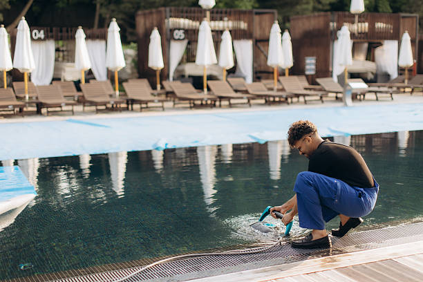 istock Pool cleaner using underwater vacuum cleaner during hotel pool maintenance 2255721735