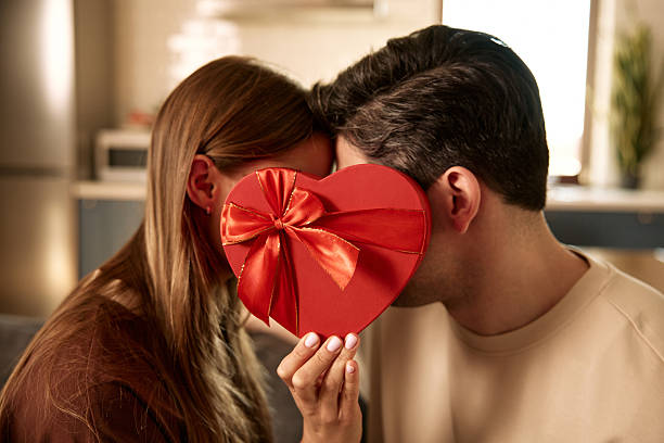 istock Couple hiding behind heart shaped gift box on Valentine's Day 2255723803