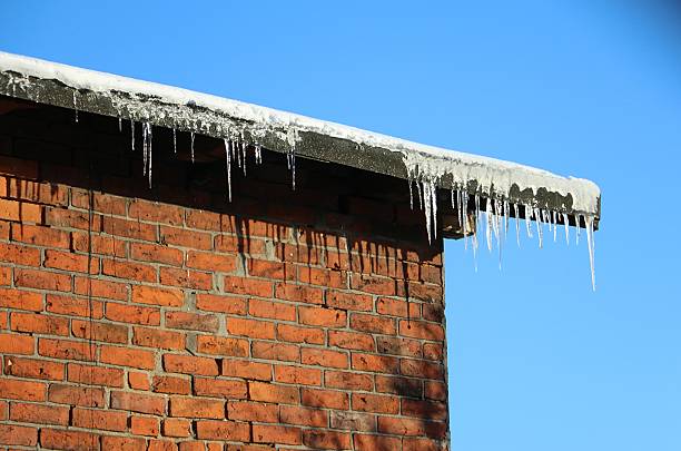 Spring and thaw. The snow melts on the roof. Icicles hang from the roof