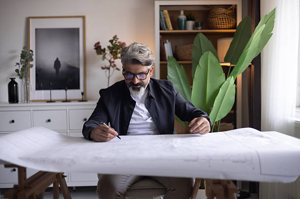 istock Architect designing a new project using a ruler and pencil with laptop 2255728232