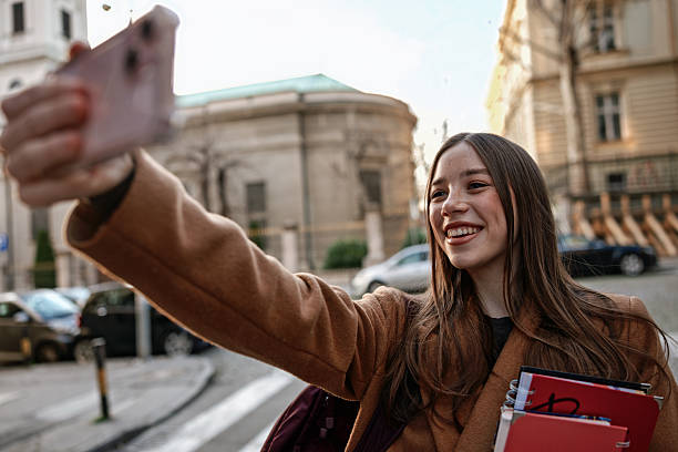 istock Smiling Female Student Talking on Smartphone While Walking Outdoors 2255729556