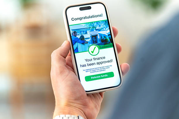 istock Man holding a mobile phone with a financial loan approval message on the screen. 2255744206