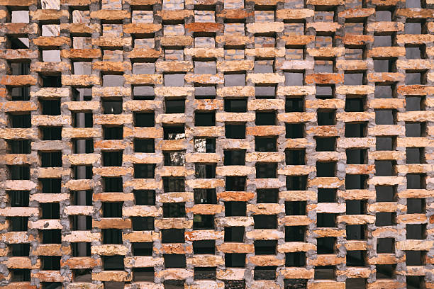 Close-up of decorative brickwork with staggered pattern and natural stone texture, abstract architectural background for construction and design concepts. Selective focus.