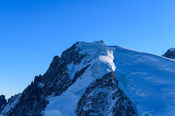 The mountain range is covered in snow and the sky is clear and blue. The snow-covered peaks are majestic and the view is breathtaking