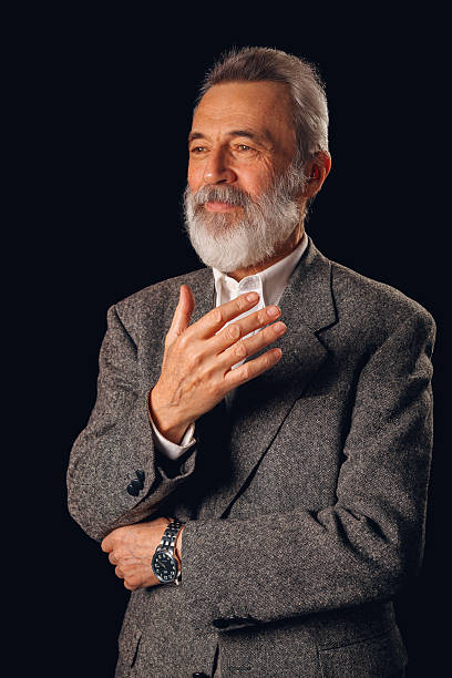 Senior adult man in a suit, looking thoughtful and gesturing with his hand