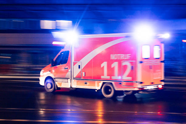 istock emergency ambulance with flashing blue lights in motion at night 2255754576