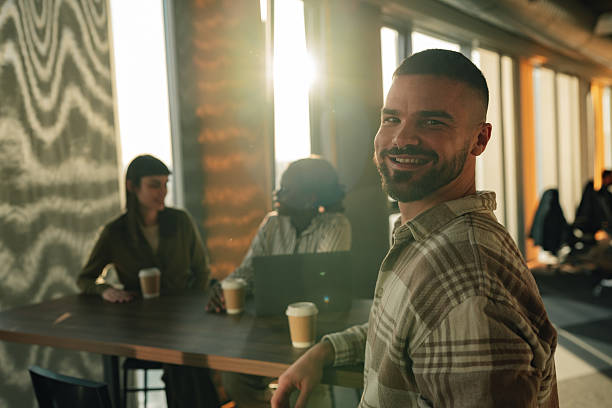 istock Man smiling casually in modern office with colleagues 2255760595