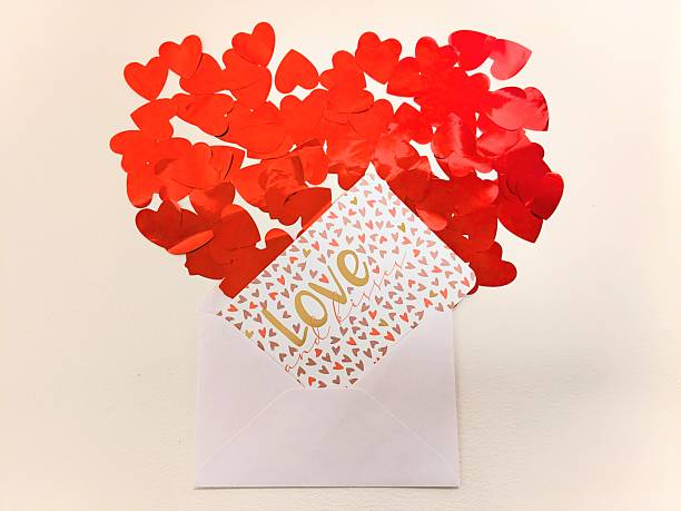Valentine's Day decor. Top view. A white background with a beautiful card and red confetti in a heart shape. High quality photo
