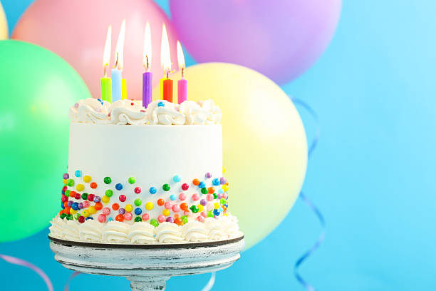 istock Delicious bento cake with sprinkles and burning candles on light blue background, closeup. Space for text 2255772698