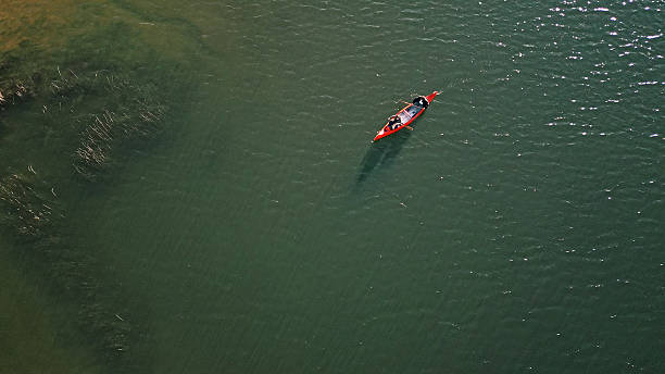 istock Couple Paddling a Red Canoe on a Serene Lake 2255778900