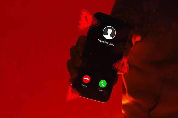 istock Hand holding smartphone with incoming call screen and warning alert symbols on red background. Concept of phone scam, cyber fraud, identity theft, cybersecurity threat and digital danger. 2255779978