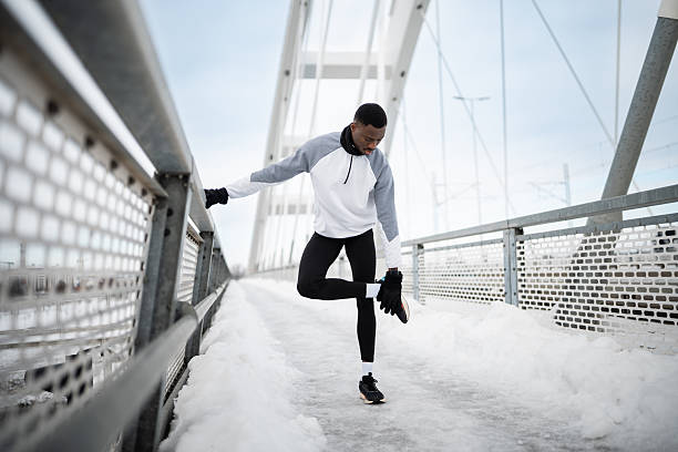 istock African american man stretching on snowy bridge 2255782003