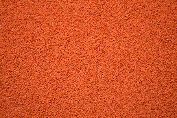 The image shows a close-up of a smooth, coral-colored surface with a subtle texture. Its uniformity and fine grains create a calming, simple aesthetic. Macro shot of a used blush palette
