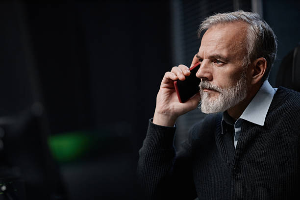 istock Caucasian Middle Aged Man Talking on Smartphone in Modern Office Setting 2255817662