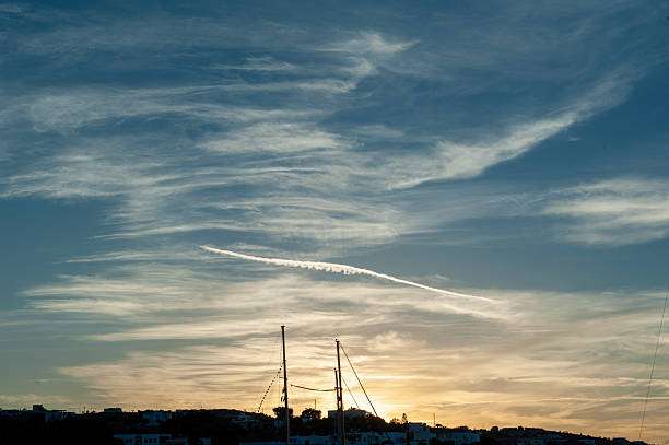 Yacht masts in harbor at sunset