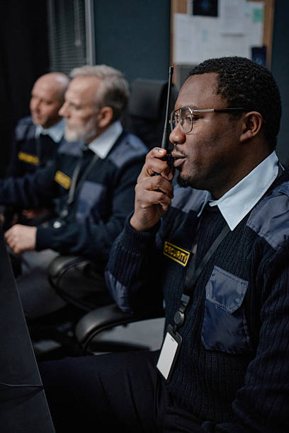 istock Middle Aged Black Man Coordinating Security Operations Using Walkie Talkie Indoors 2255822226