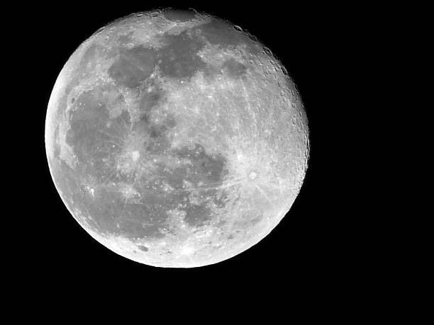 Almost full moon shining in the dark night with no stars