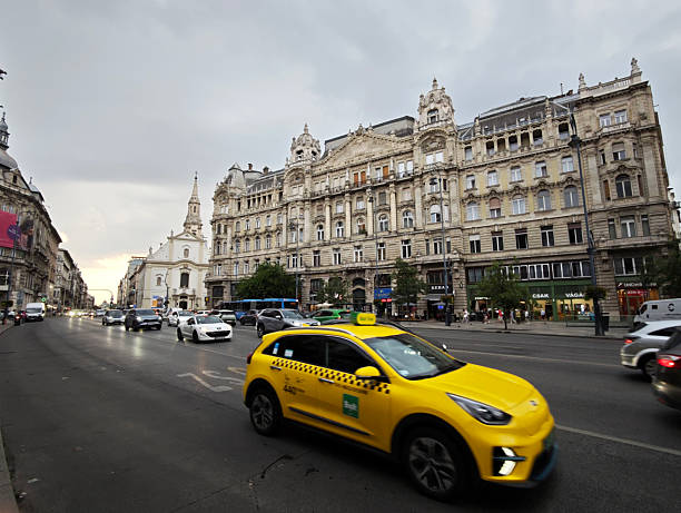 Traffic on the street by a majestic old fashioned palace in downtown Budapest, Hungary.
