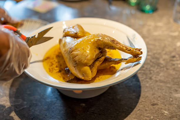 The raw carcass of a quail for the grill on the skewer on a light background.