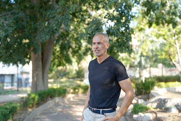 istock A man in a black shirt stands in front of a tree 2255838571
