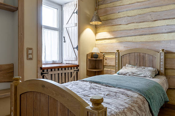 istock Cozy rustic bedroom corner with wooden bed and warm lighting 2255845565