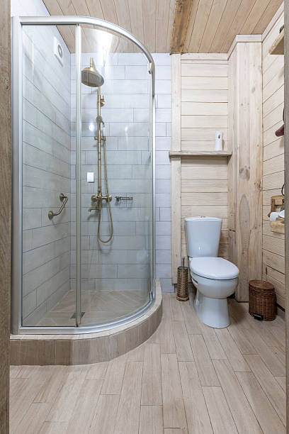 istock Bright rustic bathroom interior with glass shower and wooden walls 2255845585
