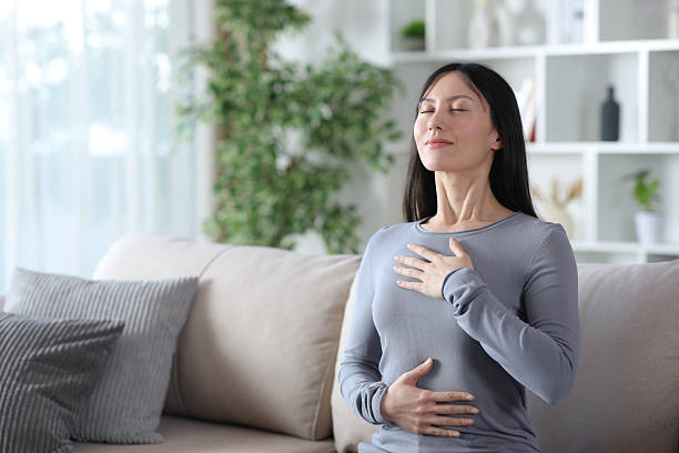 istock Asaian woman doing breathing exercises alone at home 2255853326