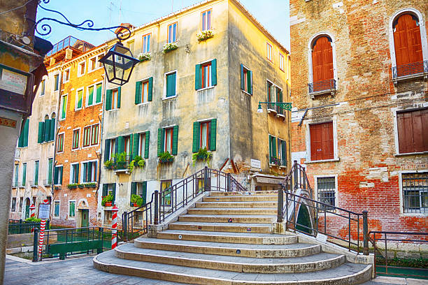 Beautiful stone bridge over the canal in a quiet street, Venice, Italy