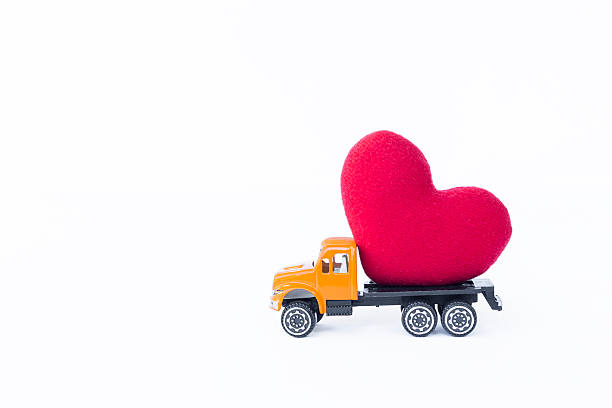 Red heart on yellow truck isolate on white background, love and romance concept, valentine on they way