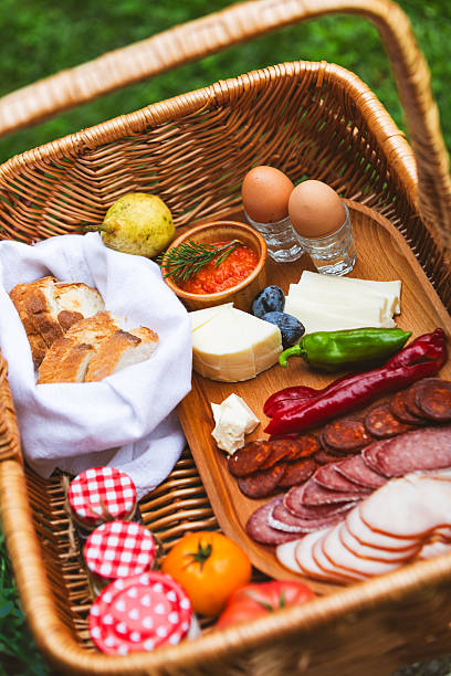 A picnic basket filled with savory delicacies, fresh produce, and artisanal bread.