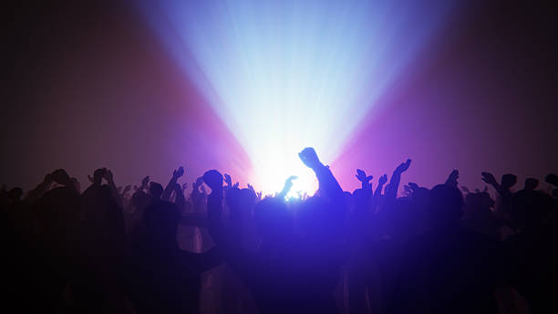 istock Concert crowd enjoying a live music performance with bright stage lights 2255863332