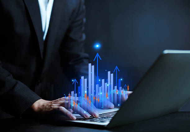 istock Businessman hand drawing glowing financial chart with rising bar graph and market data. Concept of investment growth, stock market analysis, trading strategy, financial success, and digital economy. 2255868199